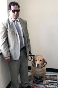 Image of Alphapointe team member Hari Dhoundiyal with his guide dog, Vital