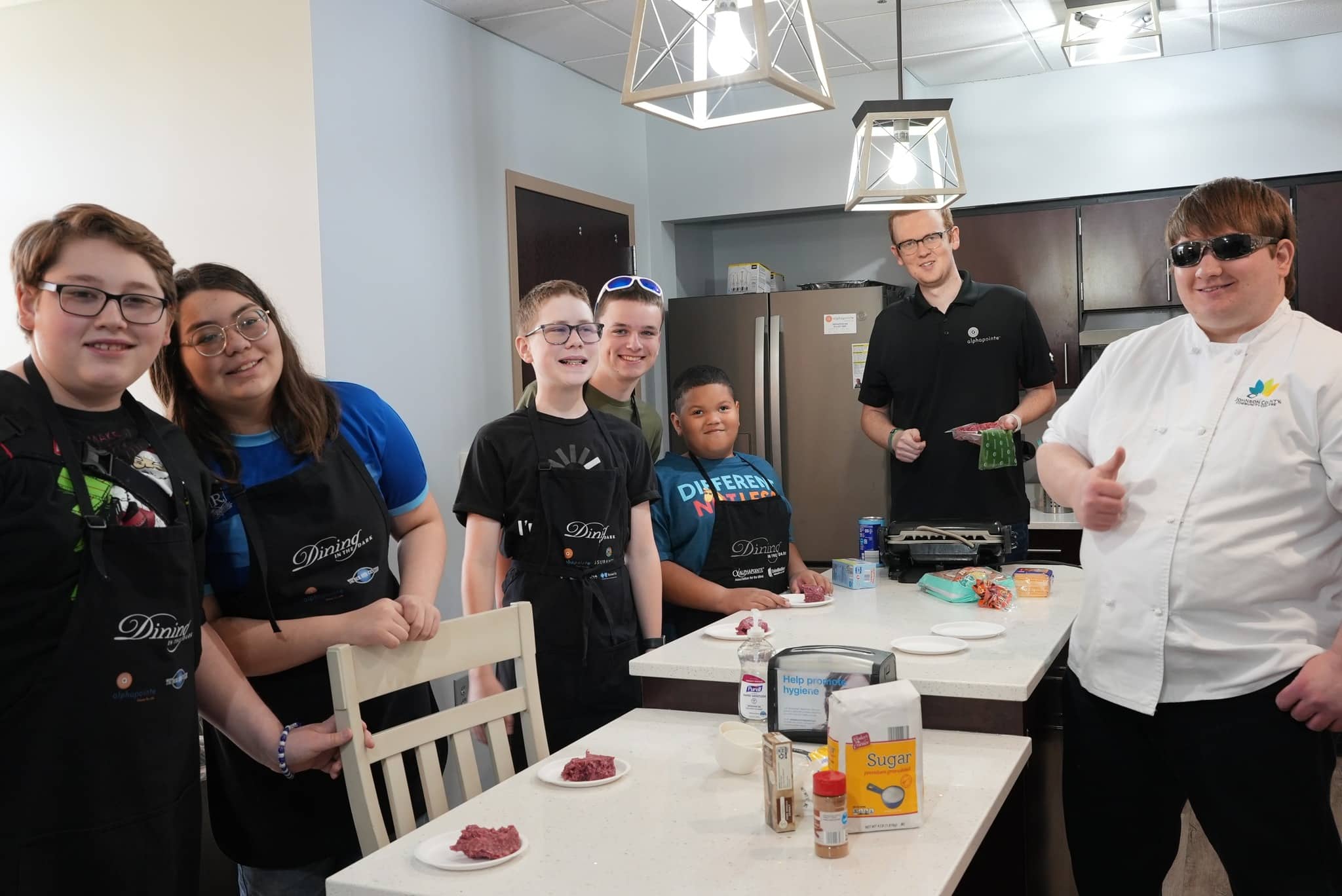 Dillon with a group of Kids in the Kitchen participants and Alex, who volunteers for numerous Alphapointe programs.