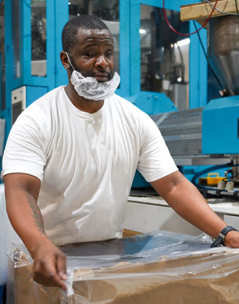 One of the Alphapointe team members is packing plastics into boxes. 