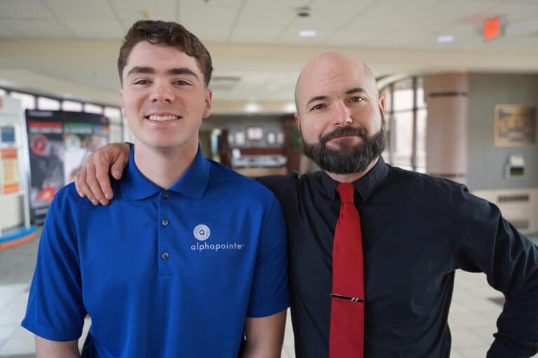 Harrison on the left is with Senior Manager of Special Events, Jake McLaughlin. They are standing in the lobby of Alphapointe.