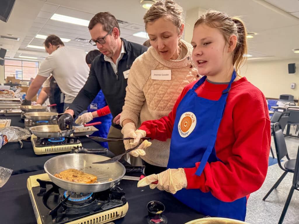 Volunteer, Jeanne, is helping Carlie work on French toast during Kids in the Kitchen.